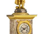 une horloge en or surmontée d'une statue d'homme