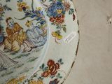 a plate with a painting on it sitting on a table