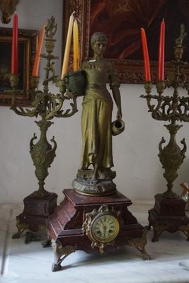 une statue représentant une femme tenant un candélabre devant lequel se trouvent des bougies
