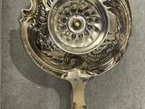 a silver plate with a spoon in it on a table