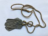 two tags attached to a rope on a white surface