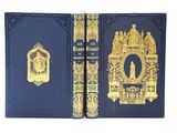 un vieux livre bleu aux bords dorés, avec l'image d'un homme assis sur un trône