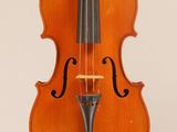 an old violin sitting on top of a white surface
