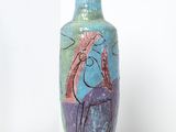 un vase avec un tableau posé sur une table
