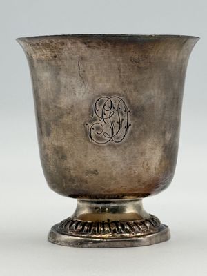an antique silver cup with a monogram on the side