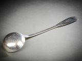 une cuillère en argent avec un manche de cuillère sur une table