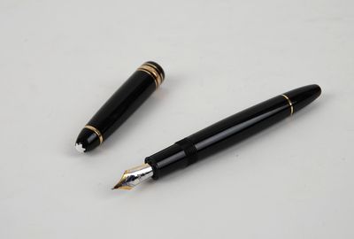 deux stylos à plume noirs et dorés posés sur une table blanche