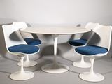 three chairs and a table in a white room