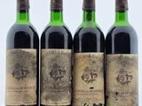 quatre bouteilles de vin sont alignées sur une table