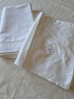 two white napkins on a bed with a white comforter