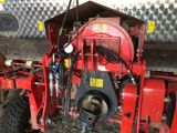 an image of a red tractor with a hose attached to the back of it