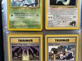 Quatre cartes Pokémon différentes sont exposées dans une vitrine.