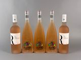 quatre bouteilles de vin sont alignées sur une surface grise