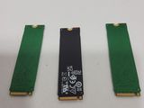 three pieces of green and black electronic components on a white surface