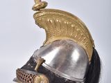 a helmet with a red feather on top of it