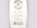a close up of a silver bar on a white surface