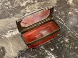 a small red box sitting on a marble table