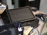une tablette posée sur un bureau, à côté d'autres fournitures de bureau