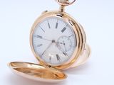 a gold pocket watch with roman numerals on it