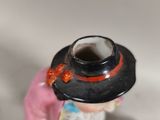 a figurine of a woman with a hat and a dog