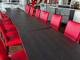 a long table with red chairs in the middle of the room