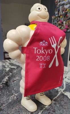 une figurine représentant un chef tenant une fourchette et un couteau