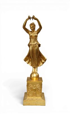 gold statue of a woman holding a bird on a pedestal