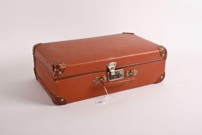 a small brown suitcase sitting on a white surface