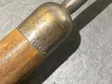 a small metal object with a wooden handle on a table