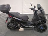 a black scooter parked on a checkered floor