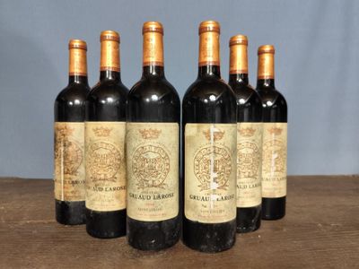 six bottles of wine sitting on top of a wooden table