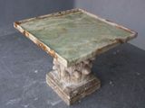 a small table with a green marble top on a gray floor