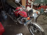 a red motorcycle parked in a garage next to a red motorcycle
