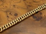 a close up of a wooden table with a gold chain on it