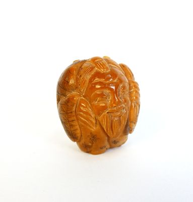 Netsuke en noix de corozo sculptée figurant un sage barbu.