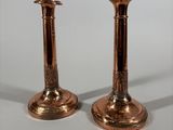 pair of antique copper candlesticks on a white background