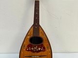 an old wooden guitar is sitting on a white surface