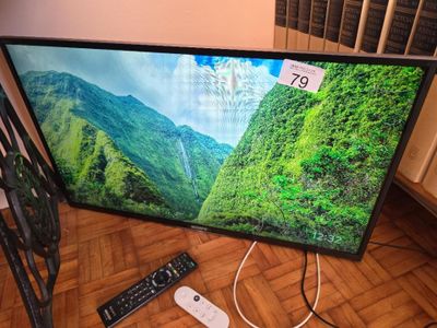 a tv that is sitting on the floor with a remote