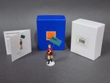 une petite figurine représentant un homme tenant un drapeau