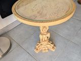 une petite table avec un plateau en verre, posée sur un sol carrelé