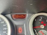 un gros plan du tableau de bord d'une voiture avec un voyant rouge