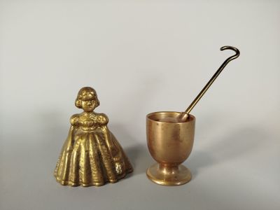 une coupe et une cuillère en or posées l'une à côté de l'autre sur une table