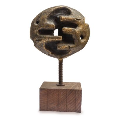 statue représentant un visage, posée sur un socle en bois, sur fond blanc
