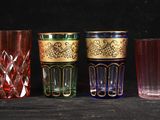 plusieurs verres de différentes couleurs sont alignés sur une surface noire