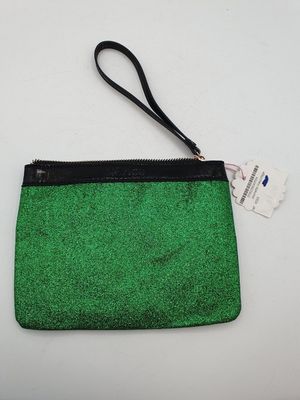 a green purse with a black strap and a tag on it