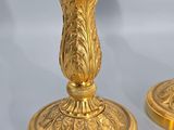 two gold candlesticks that are sitting on a table