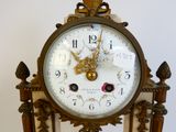 a clock that is sitting on a stand on a table
