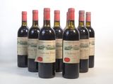 six bouteilles de vin sont alignées sur une surface blanche