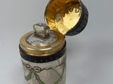 a glass jar with a gold lid on a white surface
