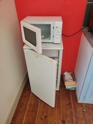 a small white microwave sitting on top of a small white refrigerator